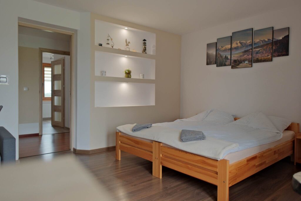 Część sypialna w pokoju z balkonem w Noclegach u Mani Część sypialna w pokoju z balkonem w Noclegach u Mani